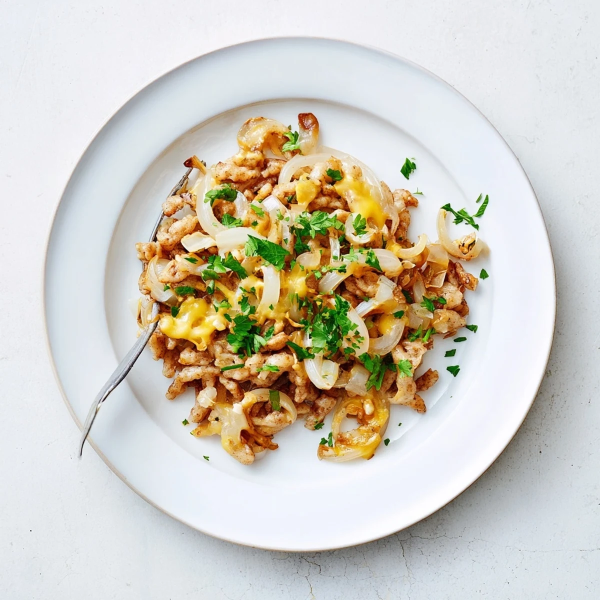 A close-up of a bubbling cheesy spaetzle skillet, golden brown and ready to eat.