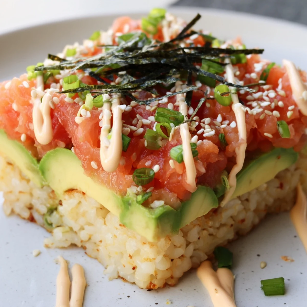 Close-up of a plated crispy rice salmon stack; perfect for a Japanese-inspired appetizer.