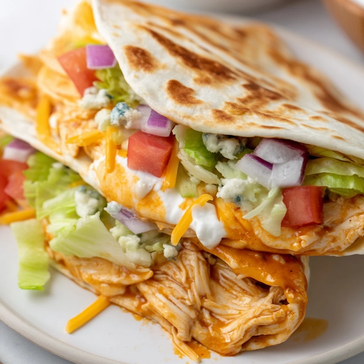 Golden brown buffalo chicken wrap, packed with savory chicken, cheese, and crunchy veggies, ready to eat.