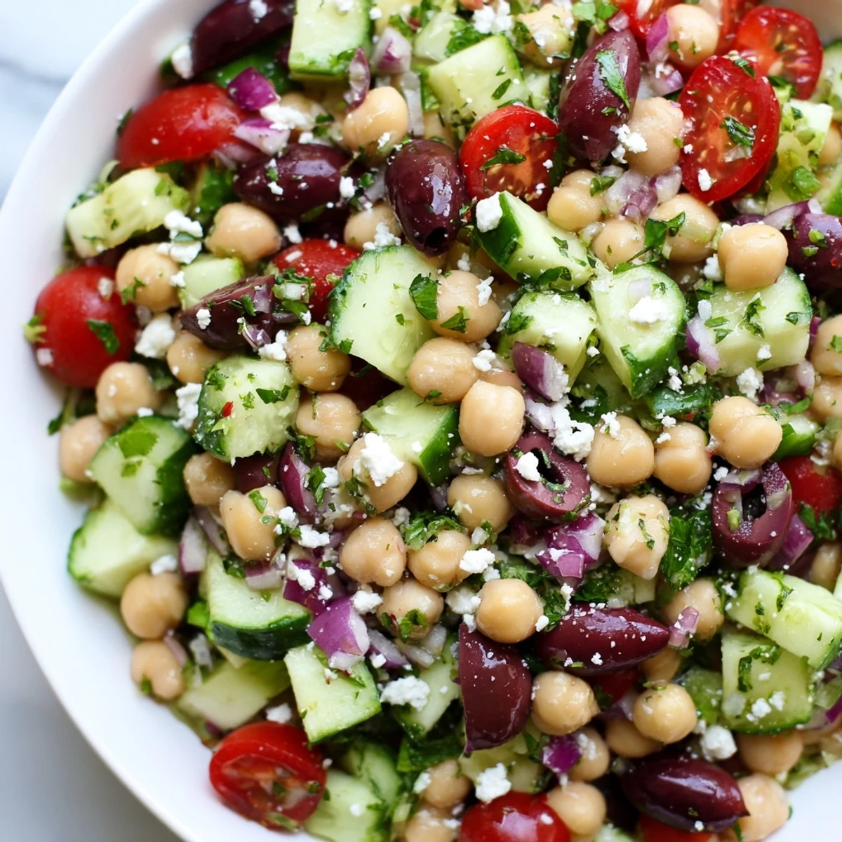 A colorful Mediterranean Chickpea Salad, featuring fresh, diced vegetables and crumbled feta cheese.
