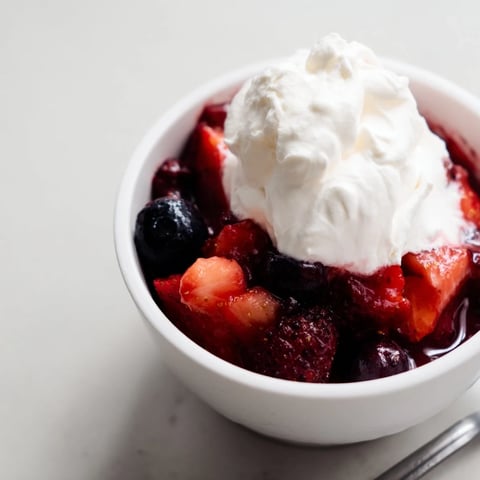 Warmer Beerencoulis mit Sahne, frisch serviert in einer Schüssel, perfekt zum Naschen.