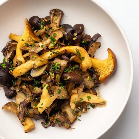 Sautéed Enchanted Forest Mushrooms glistening in a pan, ready to be deglazed with wine.
