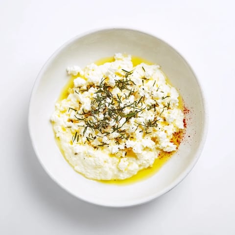 Creamy Angel Wings Whipped Feta Dip, drizzled with honey and herbs, ready to be scooped up by pita chips.