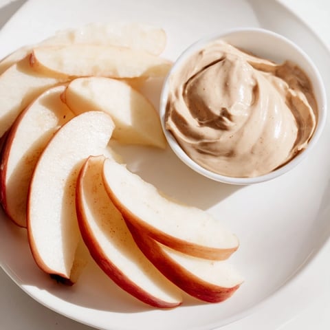 Knackige Apfelscheiben mit cremigem Erdnussbutter-Dip, ein einfacher und gesunder Snack.