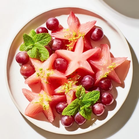 Sliced starfruit and grapes garnish: a colorful brunch fruit plate, ready for serving with mint.