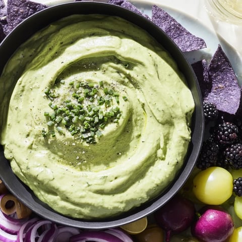 Witch's Brew Cauldron, a Halloween appetizer: creamy green dip, surrounded by dark, spooky ingredients.