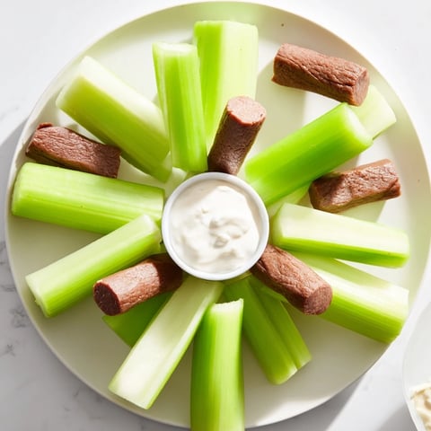 A colorful Rustic Wheel appetizer platter with crisp celery sticks and meat sticks ready to eat.