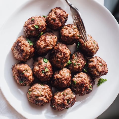Juicy Turkish Köfte meatballs, expertly grilled, offer a delightful aroma and tender, flavorful bite.