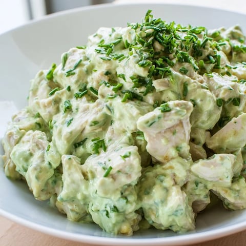 Grilled chicken chunks tossed with creamy avocado ranch, fresh veggies and herbs in a colorful salad bowl.