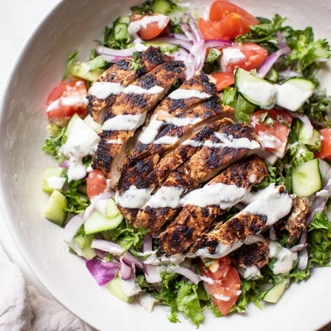 Frischer Chicken Shawarma Salad mit gegrilltem Hähnchen, knackigem Gemüse und cremigem Joghurtdressing auf einem rustikalen Teller.