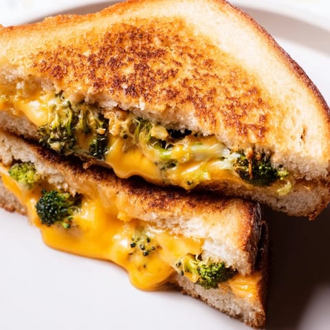 Golden-brown Roasted Broccoli & Cheddar Grilled Cheese oozing melted cheese between crispy bread slices.