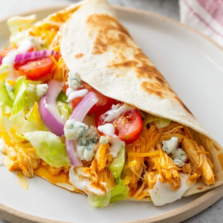 Folded buffalo chicken wrap, showing a crispy exterior and filled with creamy ranch and buffalo chicken.
