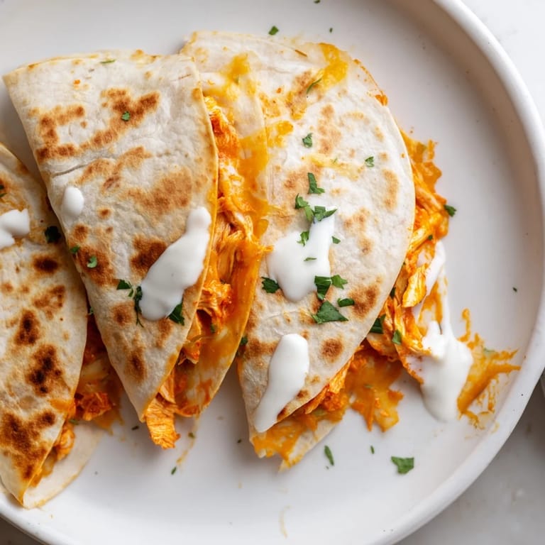 Golden-brown Buffalo Chicken Quesadilla, filled with cheesy goodness, ready for dipping in ranch.